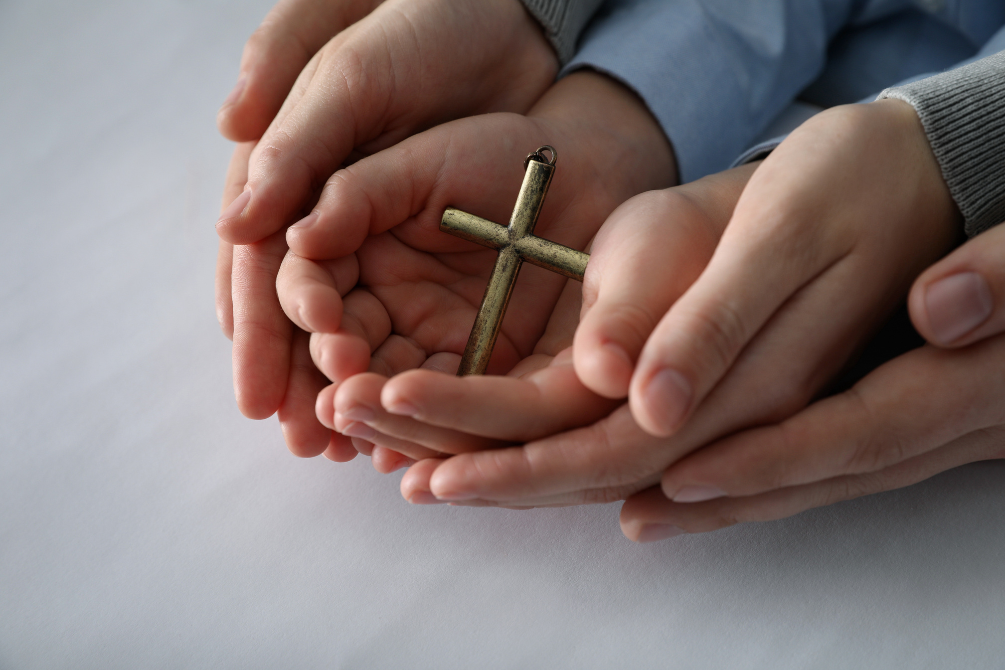 Boy and His Godparents Holding Cross on White Background, Closeu